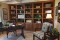 A home office with dark wood custom cabinetry and two chairs.